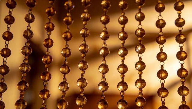 Shimmering amber beaded curtain in cozy interior with faceted glass beads and warm glow