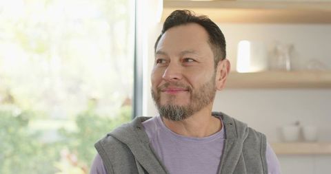 Mature Man Standing by Window in Modern Kitchen