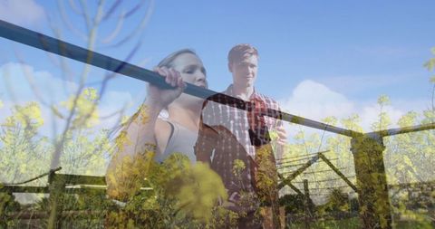 Athletic woman exercising outdoors with trainer overlooking blossoming field