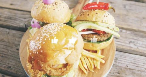 Serving gourmet sliders with avocado, brioche buns and fries on rustic wooden board
