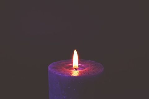 Serene Purple Candle Burning in the Darkness
