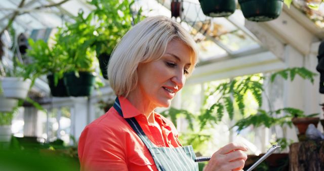 Female Gardener Doing Inventory at Greenhouse - Download Free Stock Images Pikwizard.com