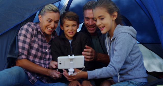 Happy Family Watching Video on Smartphones in Camping Tent - Download Free Stock Images Pikwizard.com