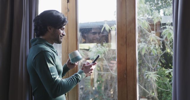 Man Relaxing at Window with Smartphone and Coffee - Download Free Stock Images Pikwizard.com