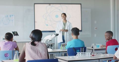 Science teacher leading classroom laboratory experiment on atomic structure