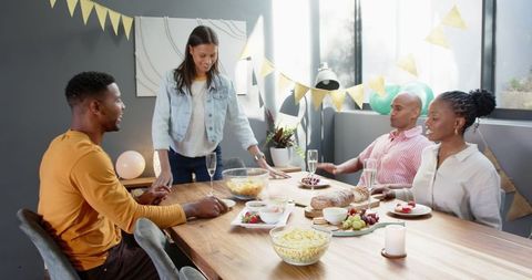 Friends Cleaning Table After Celebrating Birthday Party
