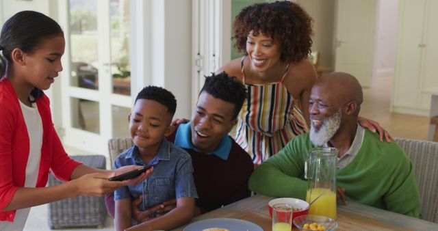 Multigenerational family enjoying breakfast together at home. Perfect for use in advertisements, family-themed campaigns, articles on family togetherness, lifestyle blogs, or healthy living magazines.