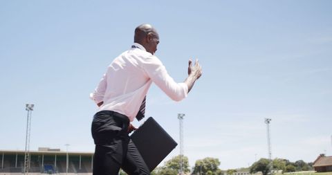 Businessman Sprinting on Running Track with Briefcase