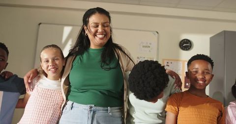 African american teacher hugging smiling elementary students in classroom showing warmth