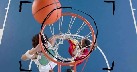 Overhead leaping players contesting basketball rim during dynamic dunk and intense aerial action
