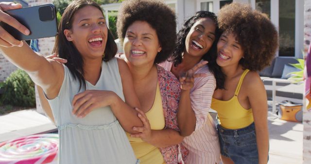 Group of diverse women taking selfie together outdoors, capturing joyful summer moments. Ideal for themes related to friendship, happiness, social media moments, and lifestyle. Perfect for blogs, advertisements, and social media content promoting unity, joy, and candid experiences.