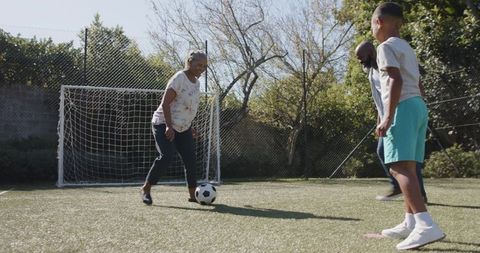 Multigenerational Family Playing Soccer Together Outdoors