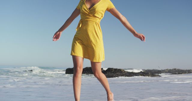 Midsection of happy biracial woman dancing on sunny beach by the sea - Download Free Stock Photos Pikwizard.com