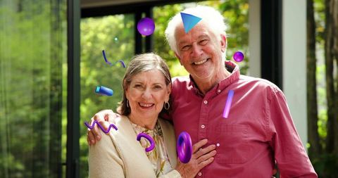 Smiling senior couple embracing on sunlit porch with glass doors and playful 3d graphics