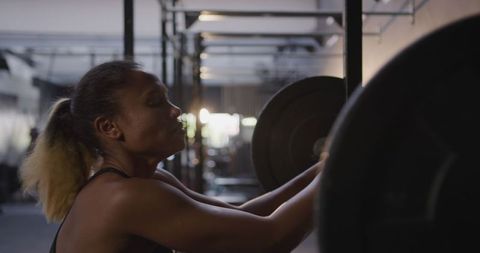Athletic woman resting after intense weightlifting workout