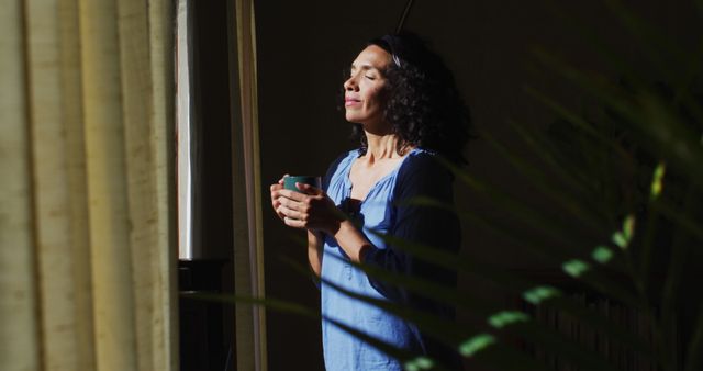 Relaxed Woman Enjoying Morning Sunlight While Holding Coffee Mug - Download Free Stock Images Pikwizard.com