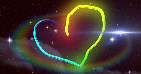 Glowing rainbow heart against starry night sky