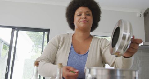 Happy plus size woman cooking at home kitchen