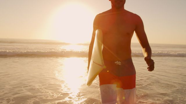 Man enjoying an energetic run along a scenic beach at sunset, surfboard in hand, creating vibrant and carefree summer vibes. Perfect for promoting beach vacations, surf events, or water sports activities. Highlights the freedom and adventure associated with ocean experiences at dusk.