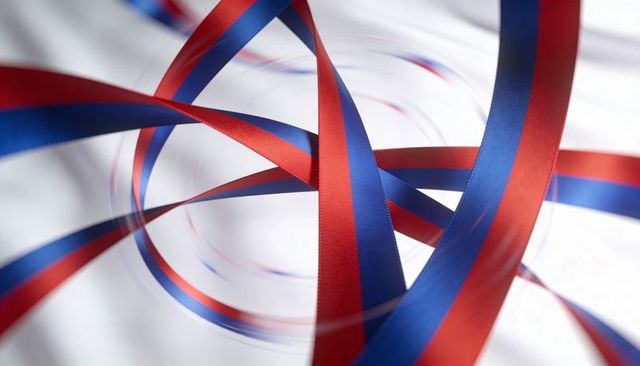 Twisting red and blue satin ribbons forming dynamic loops on white backdrop with motion