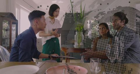 Young professionals collaborating at home dining table with halftone globe overlay