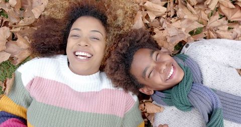 Mother and Son Enjoying Time Among Autumn Leaves Outdoors