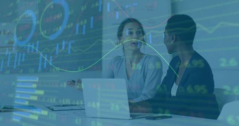 Two businesswomen discussing financial charts with laptop in analytics meeting