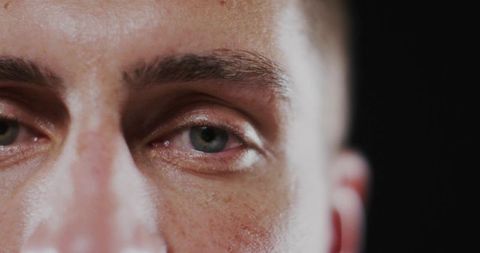 Close-up View of Man's Eyes and Skin Texture in Minimalist Setting