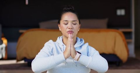 Peaceful Woman Meditating with Prayer Hands Indoors