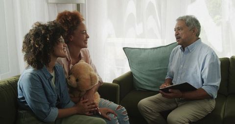 African American multigenerational family having calm conversation on green sofa at home