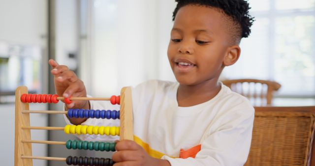 Front view of black boy playing with abacus at comfortable home. Black boy counting the blocks in abacus 4k