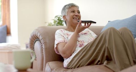Senior Woman Enjoying Conversation at Home with Smartphone