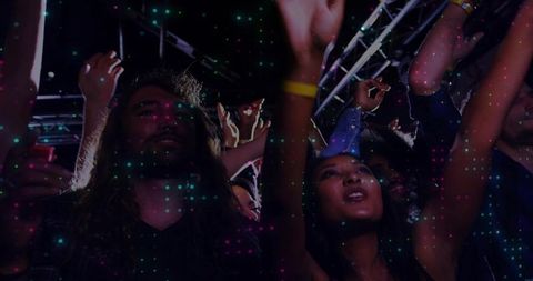 Crowd cheering at neon concert featuring bearded man and woman raising arms