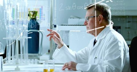 Scientist Solving Equations on Glass Board in Lab Environment
