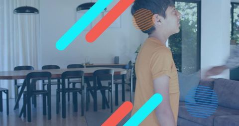 Standing boy in orange t-shirt looking right in modern open-plan living room