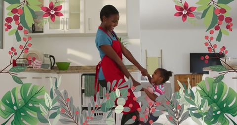 Joyful Mother and Daughter Dancing in Cozy Kitchen Space