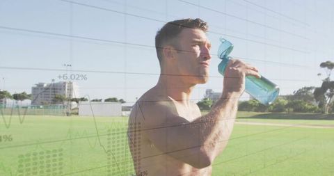 Shirtless athlete hydrating outdoors after training session
