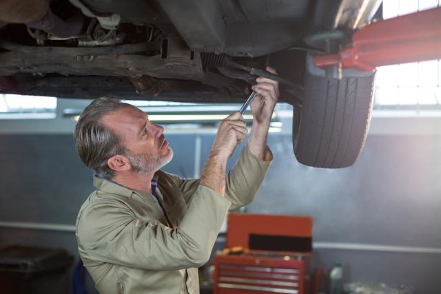 Mechanic examining car wheel brake disc in repair shop