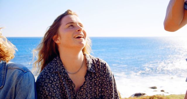 Carefree woman laughing near ocean shore during sunny day - Download Free Stock Images Pikwizard.com