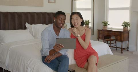 Happy Couple Video Chatting on Tablet in Cozy Bedroom Setting
