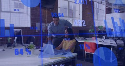 Business colleagues collaborating over laptop with data overlay in modern open office