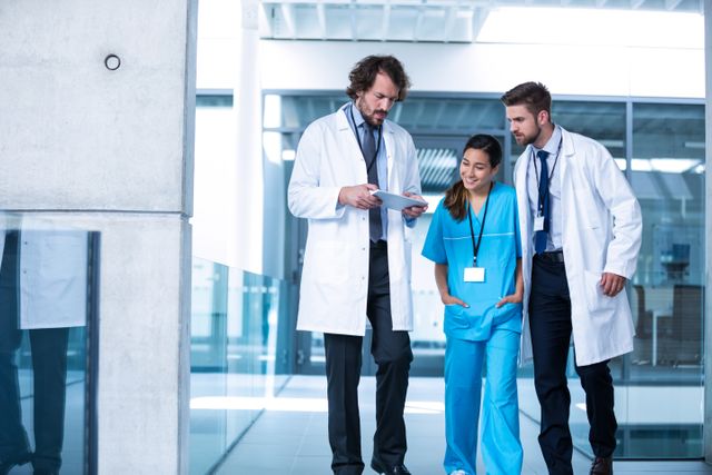 Doctors are collaborating and discussing patient care in a modern hospital environment. This image can be used for healthcare-related articles, medical websites, hospital brochures, and educational materials to depict teamwork and professional collaboration in a medical setting.