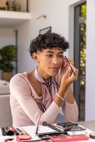Young Man Perfecting Eyebrows at Home Makeup Preparation