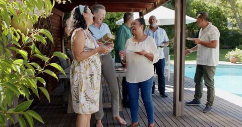 Diverse Seniors Celebrating and Socializing Outdoor by Pool on Sunny Day