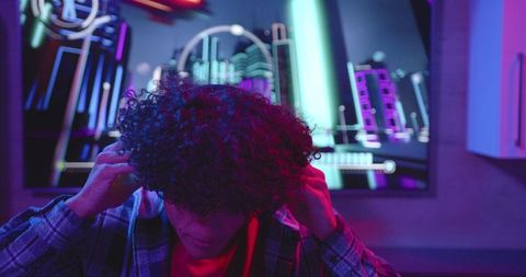 Gamer Immersed in Virtual Neon World with Headphones On