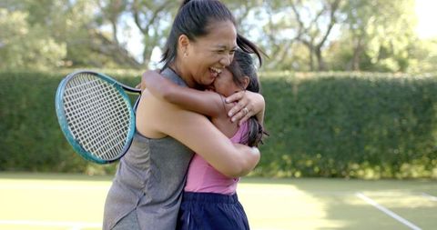 Mother and Daughter Celebrating Tennis Victory Outdoors