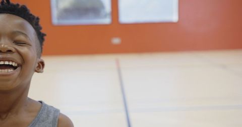 Joyful African American Boy Laughing in Gymnasium with Copy Space
