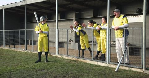 Diverse Team Cheering Batter at Baseball Dugout