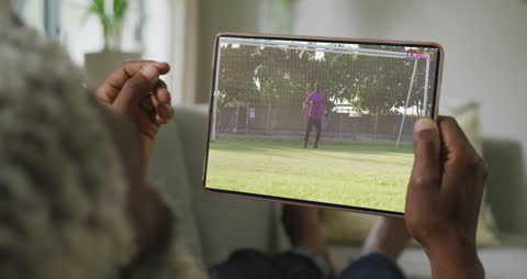Person Streaming Soccer Match on Tablet at Home