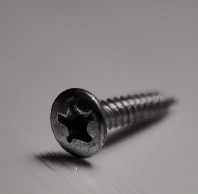 Image of close up of metal screw with copy space on grey background. Screw and fixing diy items concept.
